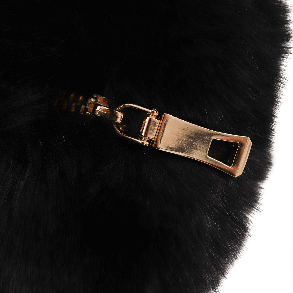 Close up of closed zipper on black faux fur heart bag.
