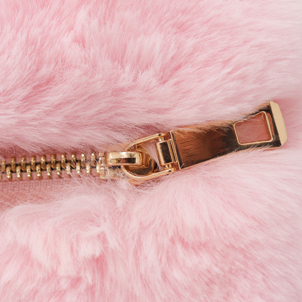 Close up of closed zipper on pink faux fur heart bag.
