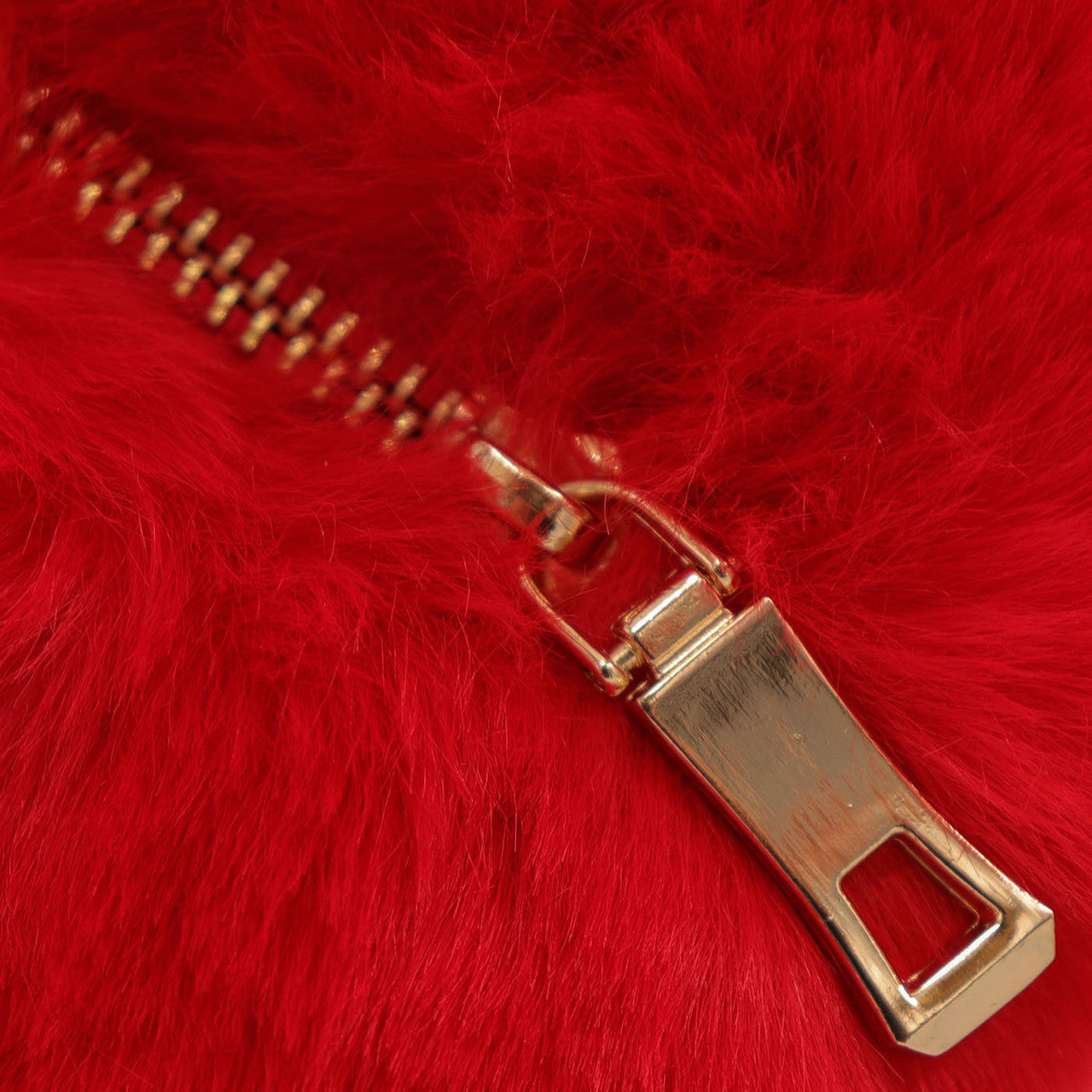 Close up of closed zipper on red faux fur heart bag.