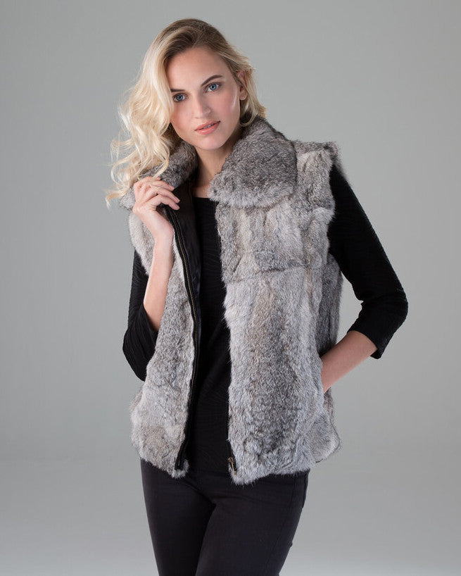 Woman with blond wavy hair wearing a gray rabbit fur vest