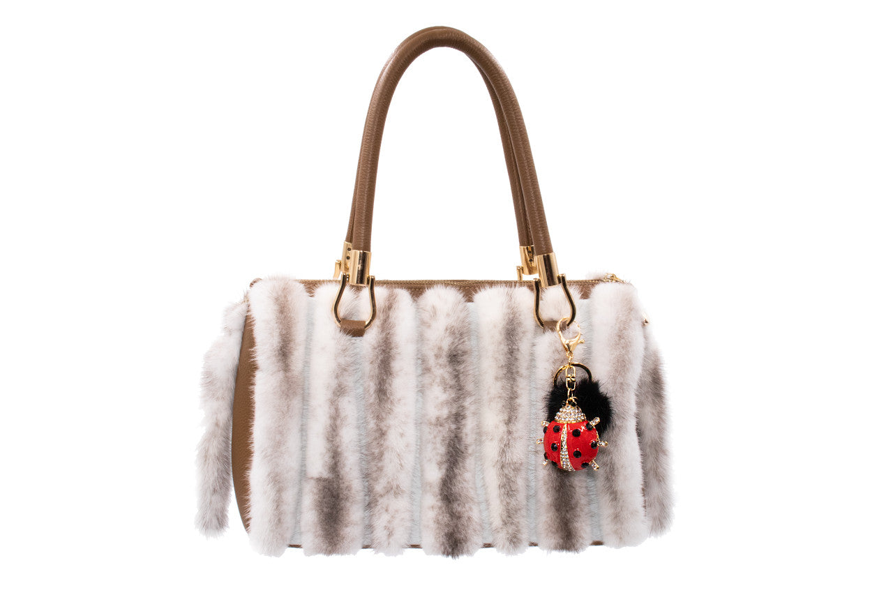 Bling Ladybug Keychain with Black Mink Pom hanging on the side of white mink purse. 